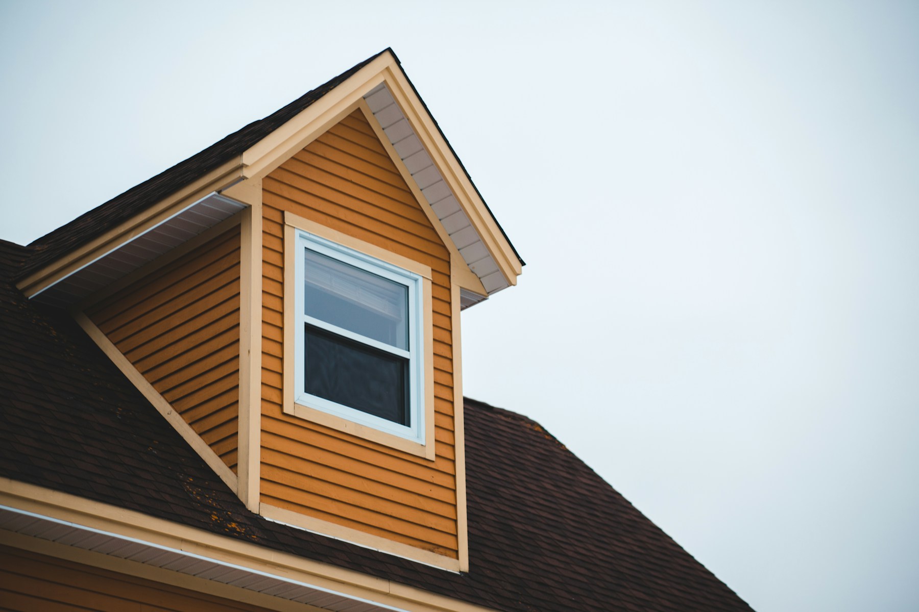 Dormer of house under white sky during daytime