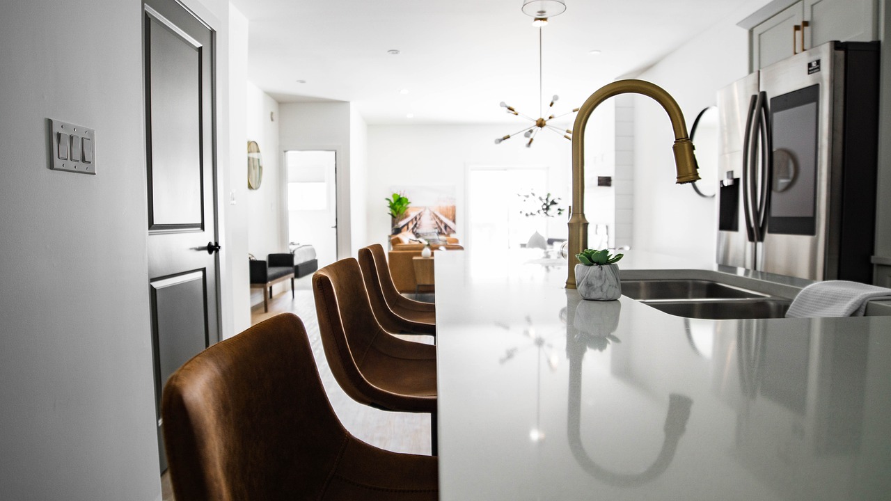 Kitchen with faucet, white counter and three chairs