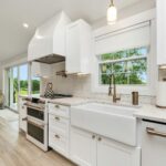 A kitchen with island and white cabinets