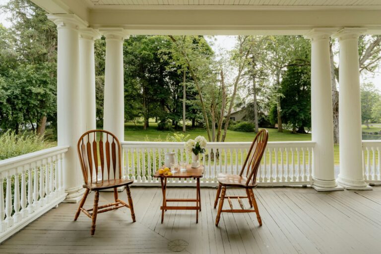 A porch with two chairs and a small table between them